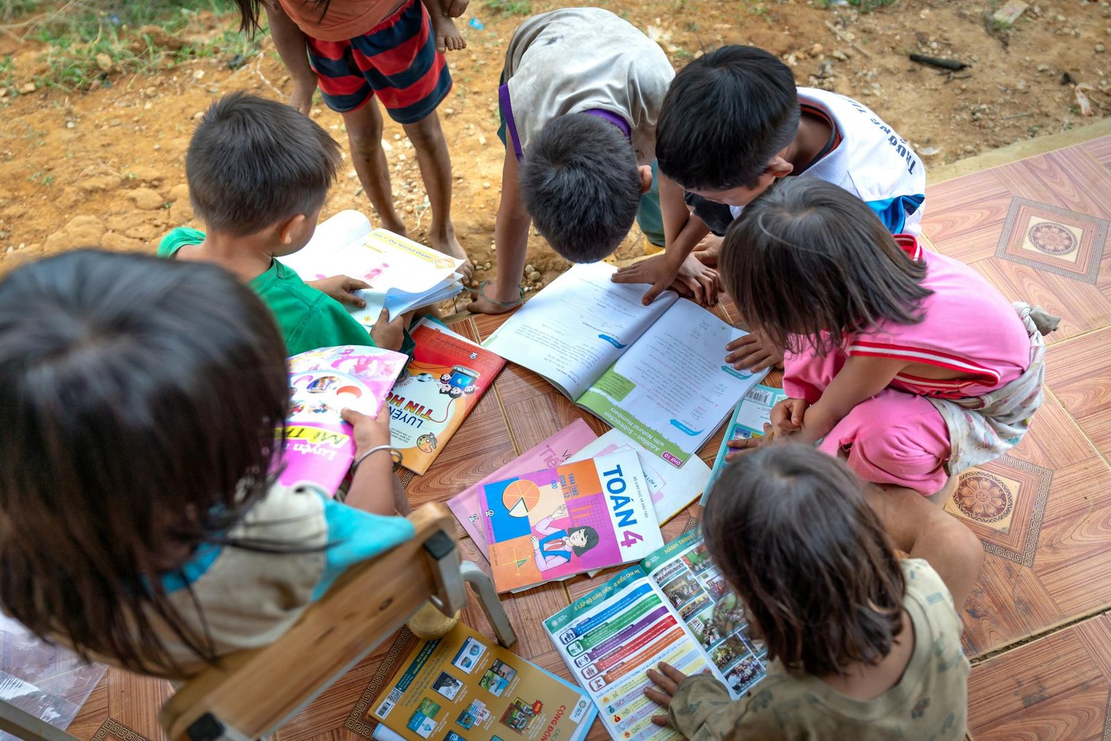 Children reading books outdoors in a learning program